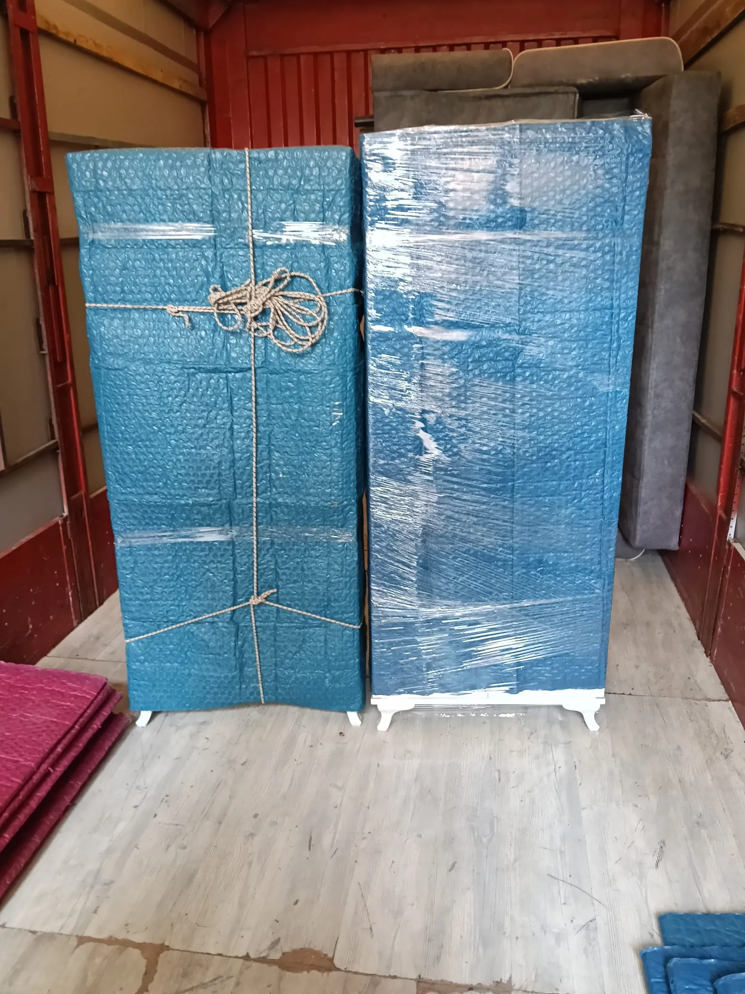 Kamyon kasasında iple sabitlenmiş ambalajlı dolaplar