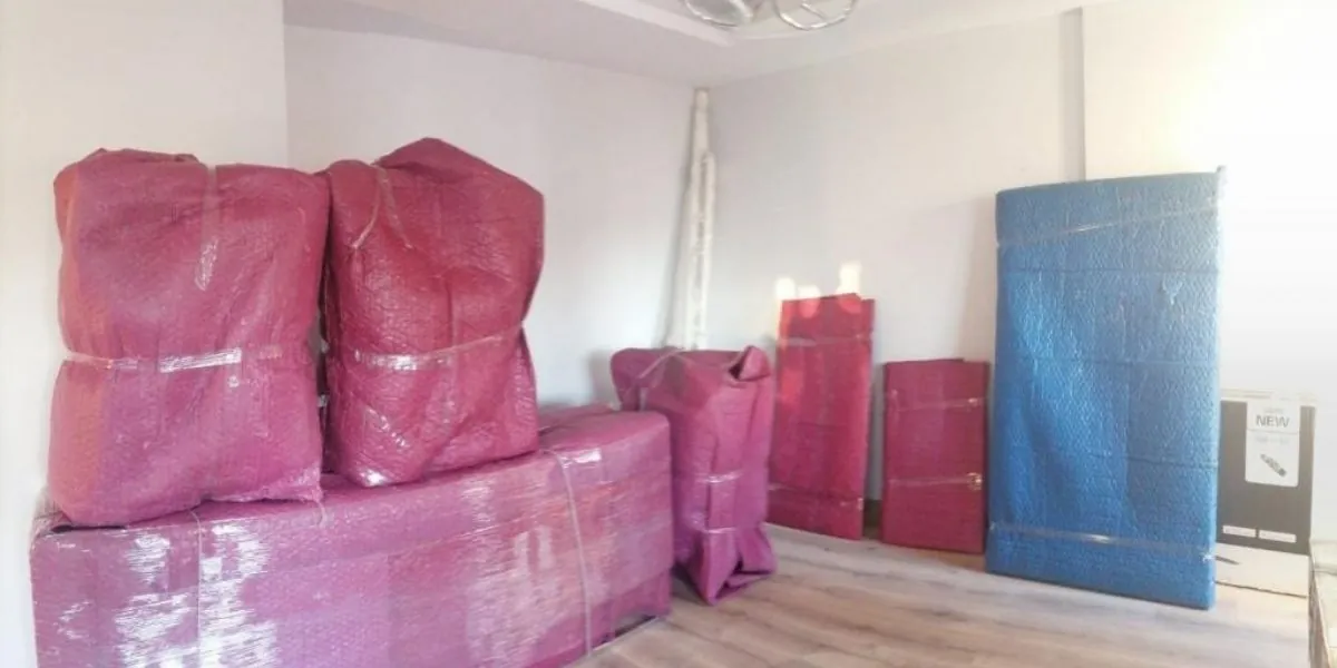 Boş odada paketlenmiş halde yüklemeyi bekleyen mobilyalar